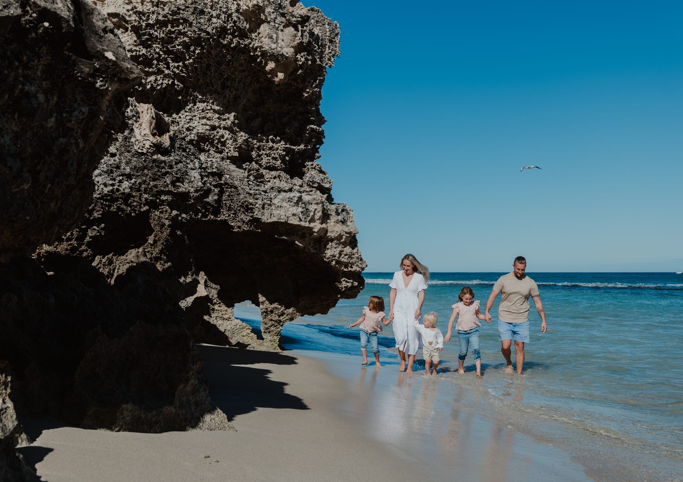 A family enjoying a sunny day at the beach, highlighting the opportunity to live by the beach