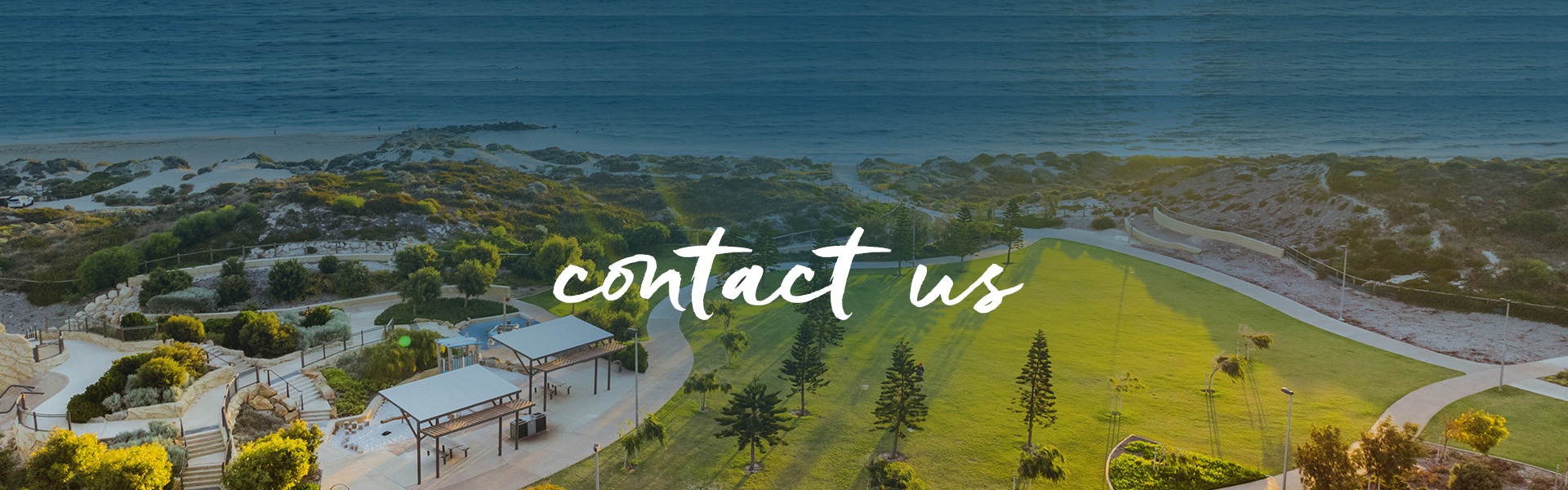 A surfer gracefully rides a wave at Capricorn Beach, captured from an aerial perspective.