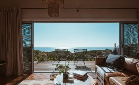 Stunning beachside living room with an open view of the ocean, featuring modern furniture and a cosy interior