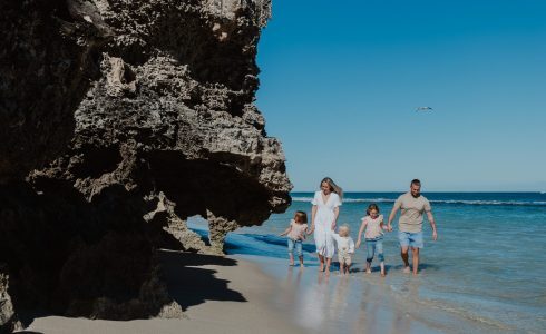 A family enjoying a sunny day at the beach, highlighting the opportunity to live by the beach