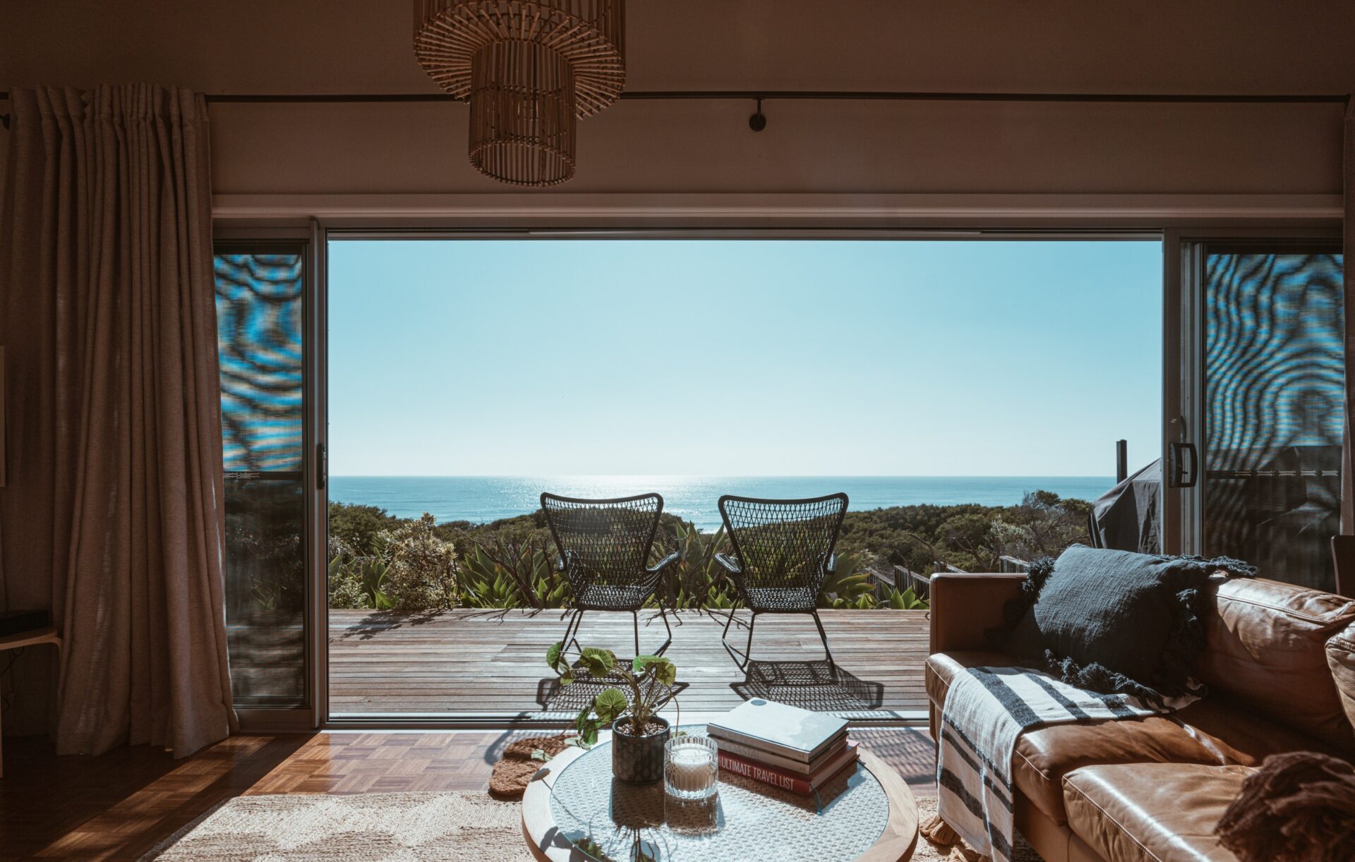 Stunning beachside living room with an open view of the ocean, featuring modern furniture and a cosy interior